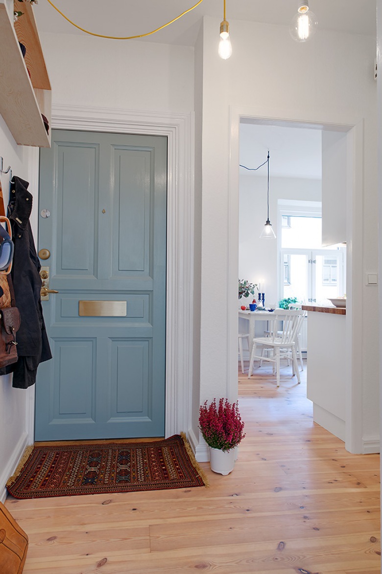 nietypowa aranżacja w skandynawskim stylu - dużo tu ciepłych detali w stylu vintage, które tworzą ciekawą mieszankę stylową. Niebieskie drzwi i inne detale wprowadzają łagodnie kolor do wnętrza, które ciepło złamane są odcieniami brązu...
