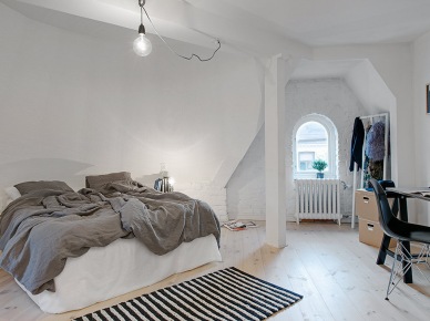 Skośna ściana z białej cegły w skandynawskiej sypialni na poddaszu (21132)