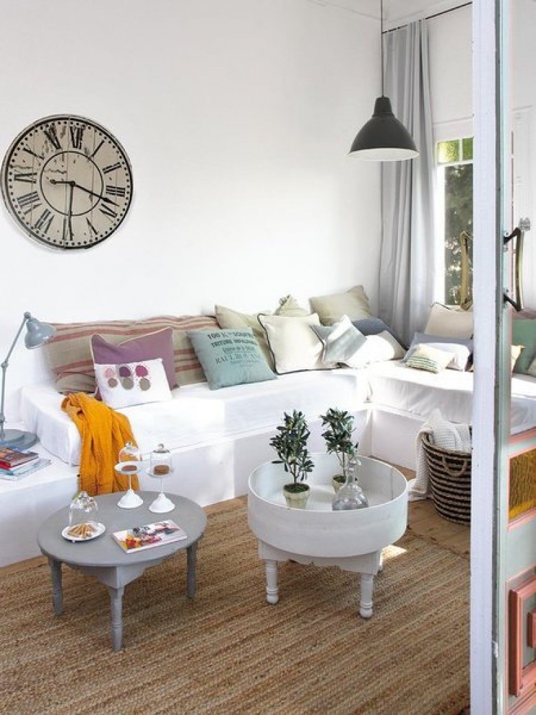Stylowe okragłe stoliki vintage,rustrykalny duzy zegar na ścianie,kolorowe poduszki na białej sofie (26432)