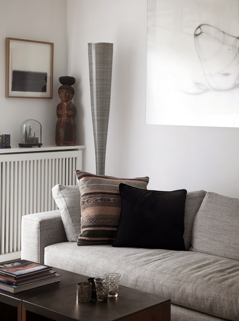 Jasnoszara sofa nowoczesna,brązowo-szara poduszka z etnicznymi wzorami,nowoczesna lampa podłogowa tuba i drewniane posążki (27020)