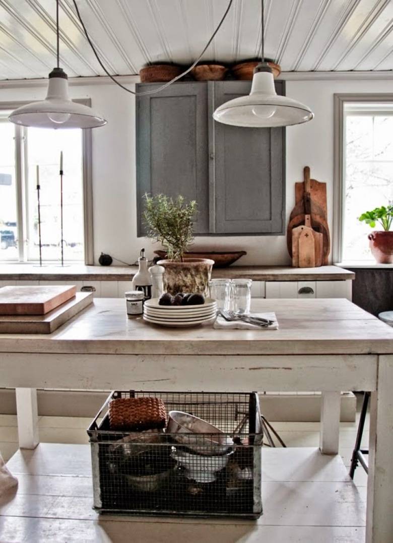 Białe metalowe lampy wiszące nad drewnianym stołem vintage,szara szafka kuchenna,drewniane deski deserowe i druciana metalowa skrzynka industrialna (24821)