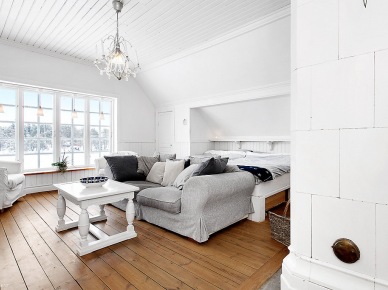 Drewniany biały stolik kawowy, szara sofa w dużej sypialni skandynawskiej (21959)