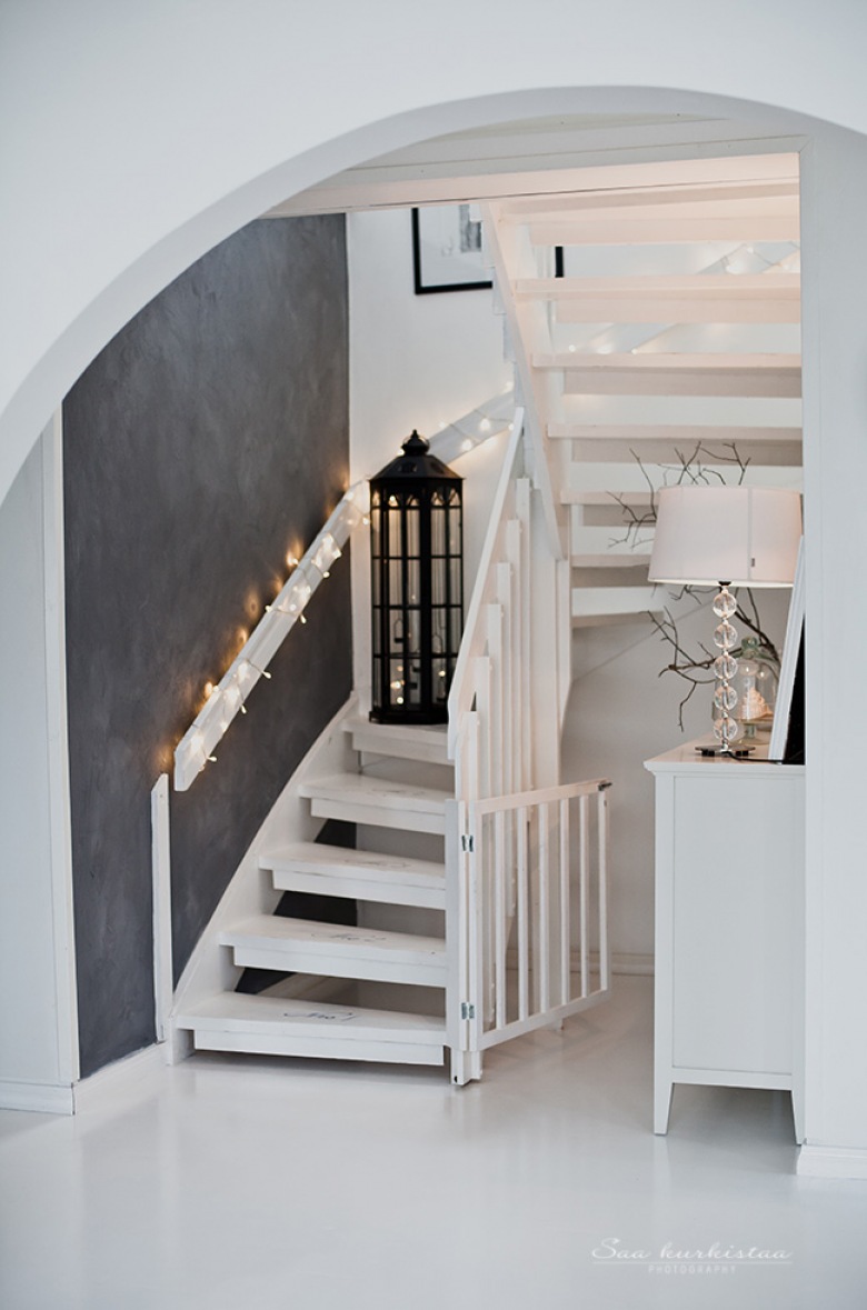 Szara ściana, lampion i girlanda z żarówkami w aranżacji białych schodów (23869)