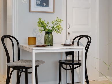 Mały biały stolik z czarnymi giętymi z drewna krzesłami  w małej jadalni (25912)