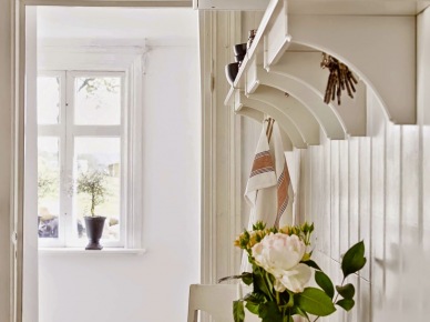 Drewniane biale półki wiszące nad drewnianym stołem z białymi tradycyjnymi skandynawskimi krzeslami (26003)