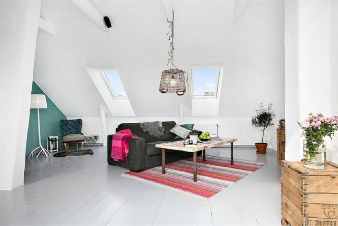 Białe deski na podłodze,skandynawski dywanik w paski,szara sofa,drewniane skrzynki i druciana lampa w salonie (25705)