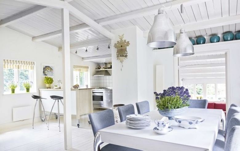 Biała otwarta kuchnia z jadalnią,białe lampy pendant nad stołem z szarymi krzeslami (26200)