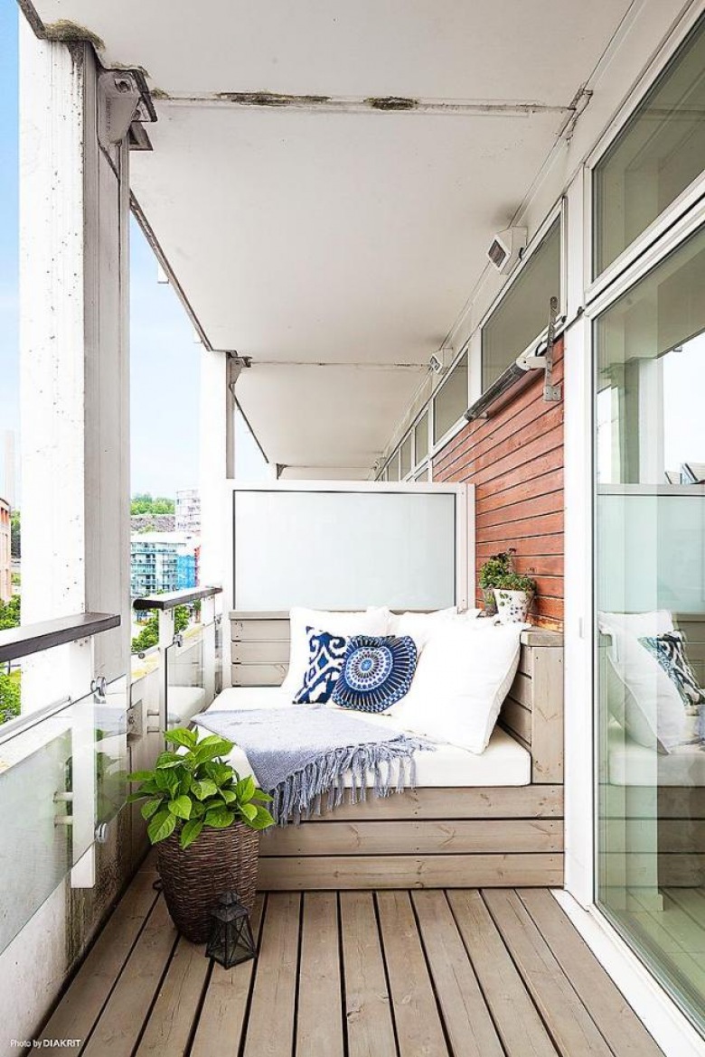 Drewniana podłoga i siedziska z niebieskimi poduszkami na balkonie (24786)