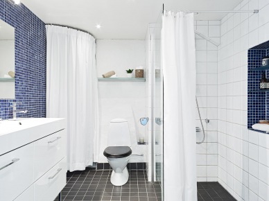 Błękitna i biała glazura w łazience, czarna posadzka i białe zasłony prysznicowe (22893)