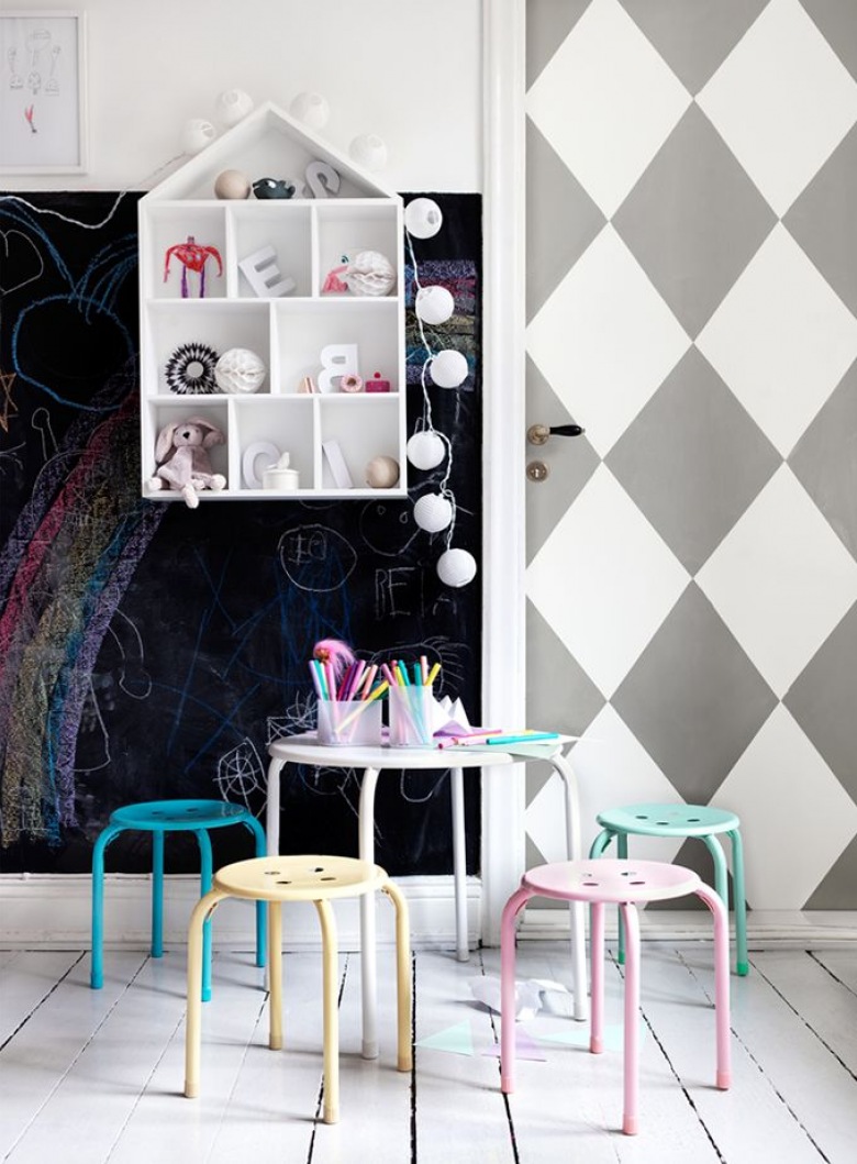 Biało-szara tapeta w romby na drzwiach i czarna ściana z farbą tablicową ,kolorowe metalowe stołki przy okragłym stoliku,półka domek  z bawełnianymi kulami z girlandą (26774)