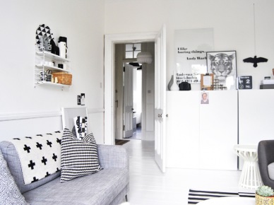 Szara sofa,nowoczesne szafki skandynawskie,białe półki i graficzne poduszki (24891)