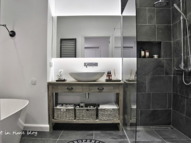 Piękna łazienka z owalną wanną,z bieloną skandynawską konsolką z półką i uywalką,grafitowe matowe płytki na ścianie i w kabinie z natryskiem (26017)