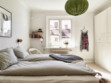 Zabudowa białych tradycyjnych szaf w sypialni z szarą pościelą i zielonym abażurem z tkaniny w wiszącej lampie (25619)