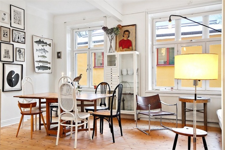 Różne krzesła z historią przy jednym stole i osobliwa galeria dekoracji na ścianie w jadalni (21871)