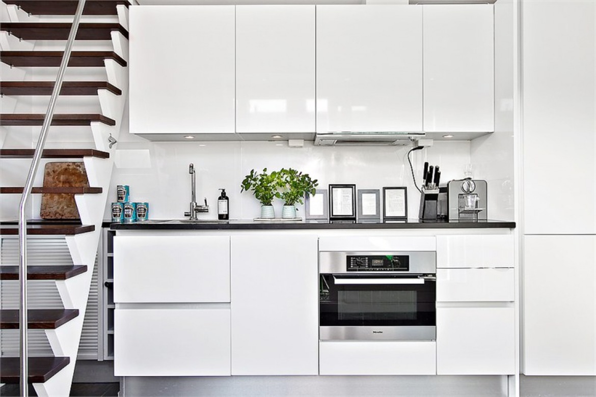 Biała kuchnia ze stromymi schodami na drugi poziom mieszkania (23191)