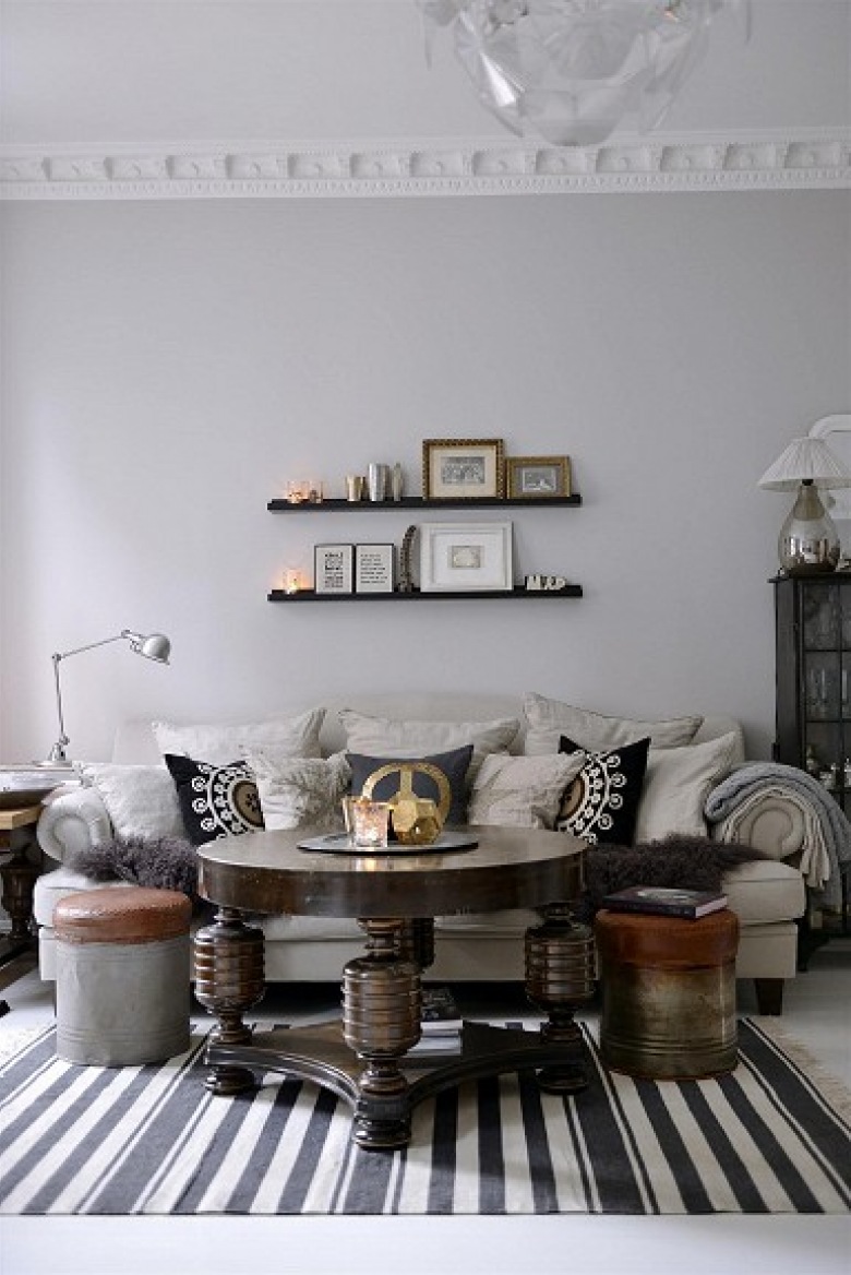 Stylowy okrągły stół,metalowe industrialne pufy i dywan w czarno-białe paski w szarym salonie (21600)