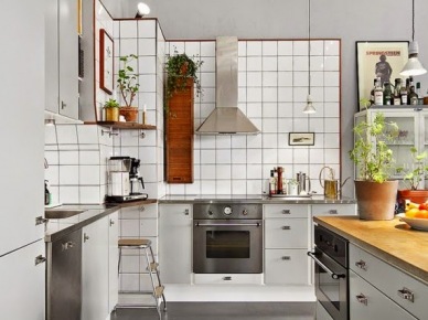 Białe płytki na ścianie w kuchni,stalowy okap,drewniana szafka vintage i szare szafki kuchenne (26386)