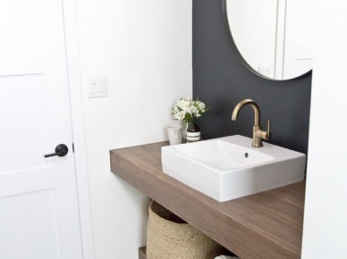 Before & after małej łazienki ze wzorzystą podłogą, czarną ścianą i złotymi dodatkami