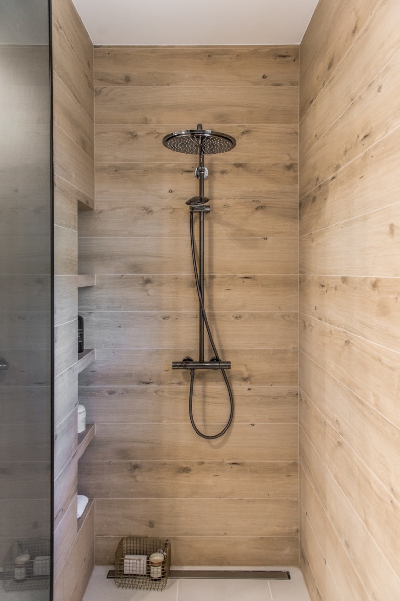 Akcenty drewna oraz czarne dodatki w łazience tworzą bardzo elegancki klimat. Prysznic jest duży i ma wbudowane półki...