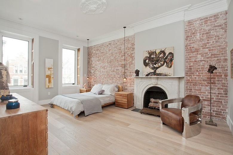 Desingerski fotel ze skóry i metalu w aranżacji sypialni ze ścianami z czerwonej cegły (24430)