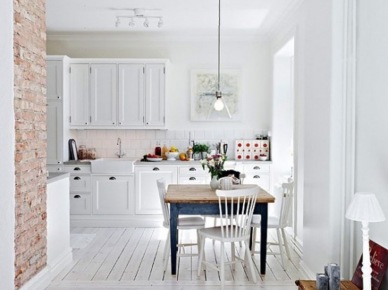 Niebieski stół,biała podłoga z desek i ściana z czerwonej cegły w rustykalnej białej kuchni (25265)
