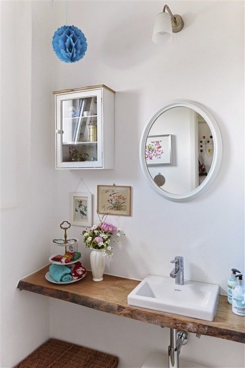 Białą łazienkę urozmaicają dodatki w żywych kolorach oraz w szczególności drewniany blat pod umywalką. Oryginalne...