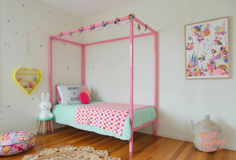 Sypialnia idealna dla dziewczynki: różowe łóżko z baldachimem i dekoracjami w postaci pastelowego nakrycia i poduszek....