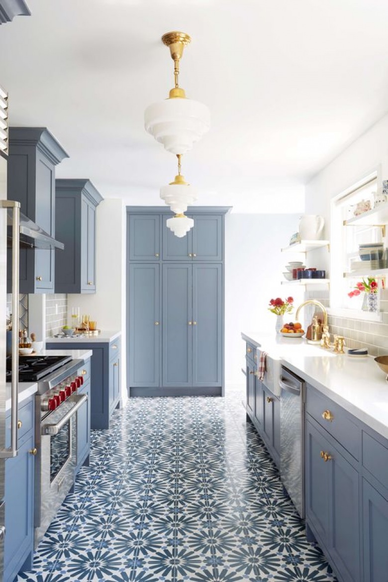 Z niebieskim odcieniem na szafkach kuchennych pięknie kontrastują złote uchwyty i drobne złote dodatki we wnętrzu. Nadają kuchni stylowe wykończenie i znacząco dekorują...