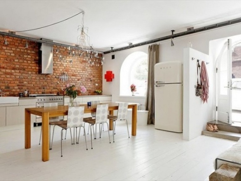 Druciane żyrandloe,biała podłoga,nowoczesne krzesła ,drewniany stół prostokatny i  ściana z czerwonej cegły w dużej otwartej kuchni (25274)