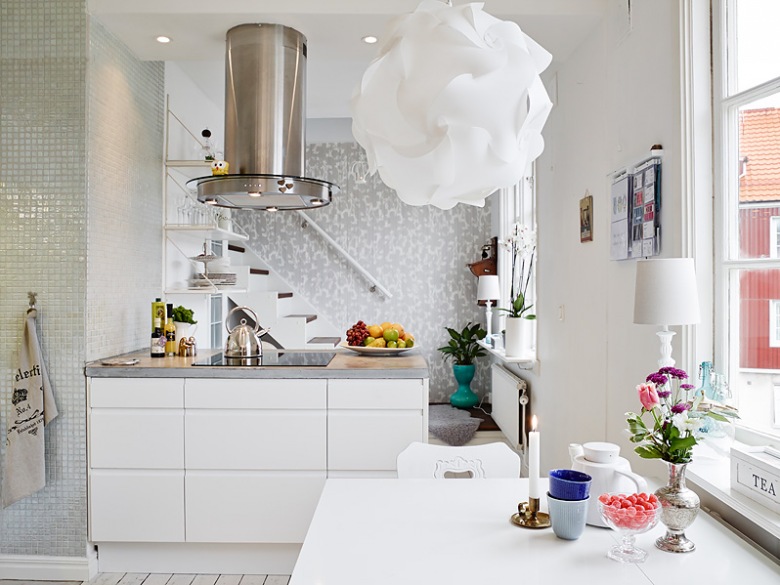 Piękna biała lampa w nowoczesnym stylu nad stolikiem kuchennym bardzo ciekawie  dekoruje całą kuchnię.