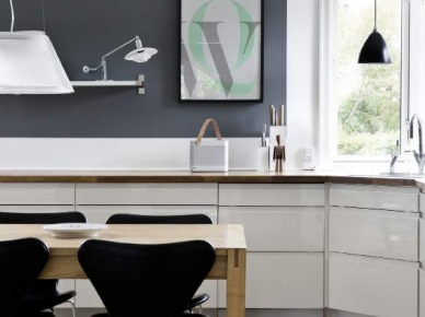 Biała kuchnia z czarną ścianą i krzesłami i drewniana naturalna podłoga z desek (21048)