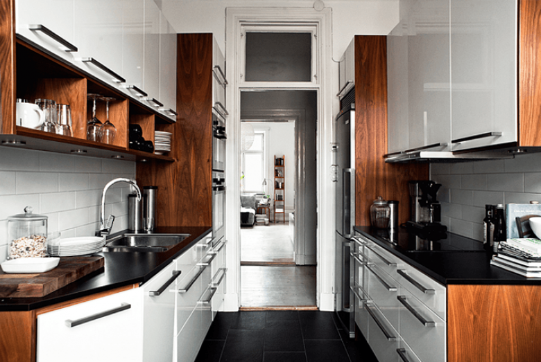 Drewniane boki szafek i czarne blaty w malej białej kuchni (21083)