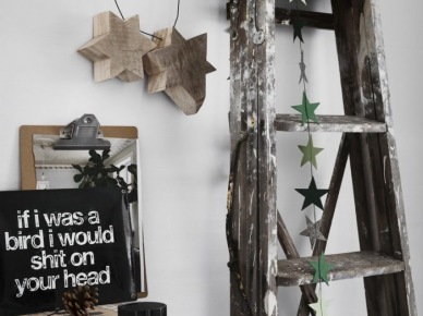 Drewniana drabina ze świątecznymi gwiazdkami z kartonu,drewniane gwiazdy wiszące na metalowym drucie na ścianie ,bielony stół z drewna (47848)