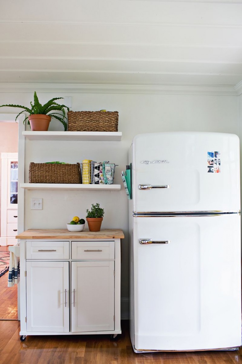 Biała lodówka oraz szafka i półki zapewniają spokojny charakter w tej części kuchni. Wiszące półki pozwalają...