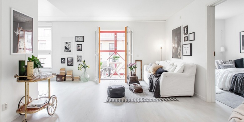 Czarny skórzany puf,barek vintage na kółkach,biało-czarny dywan w stylu skandynawskim i galeria fotografii na ścianach w salonie (24703)