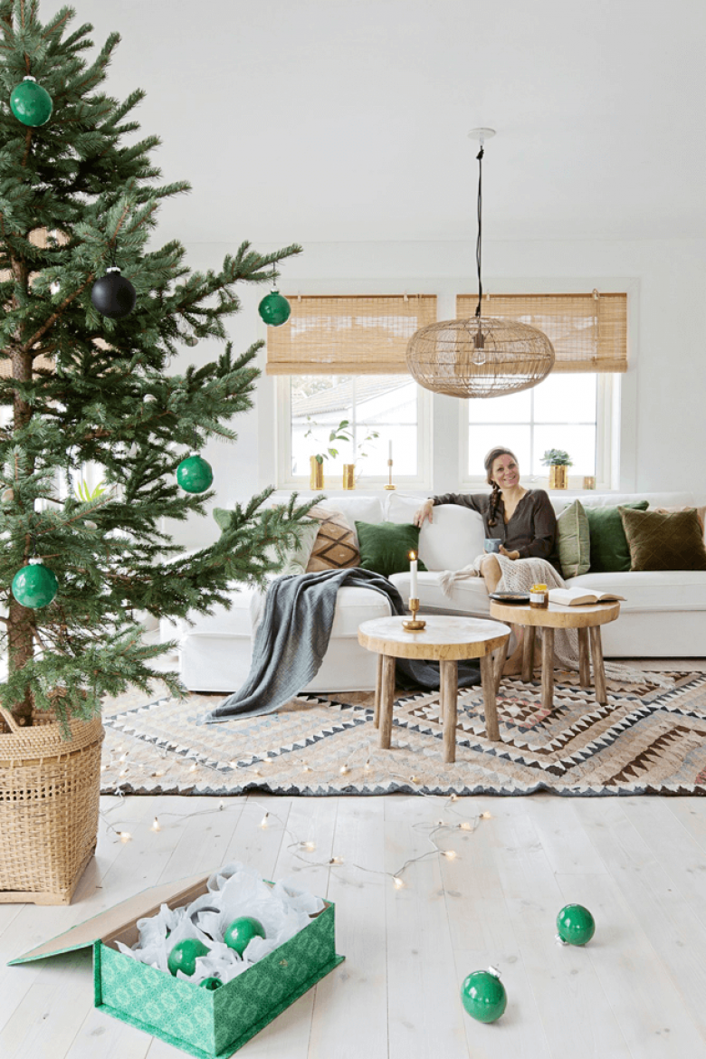 Uroczy domek w stylu skandynawskim spowity bielą od podłogi po sufit. Zielone i drewniane detale w świątecznej...