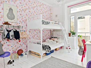 Różowa tapeta w kwiatki w pokoju dziecięcym,biała podłoga z desek,białe łóżka pietrowe z drewna dla dzieci,fioletowe dodatki (28416)