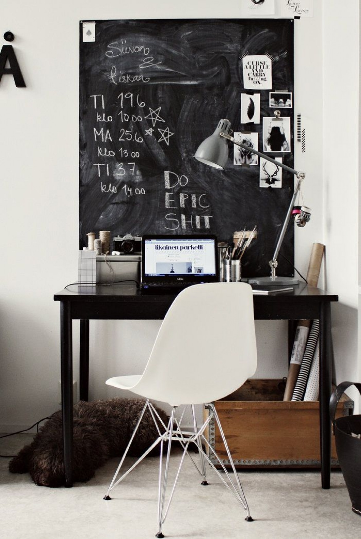 Czarne  małe biurko,czarna tablica z farba tablicową,białe nowoczesne krzesło na metalowych krzyżakach,drewniana skrzynka i szara metalowa lampa na biuo w domowym miejscu do pracy (26147)