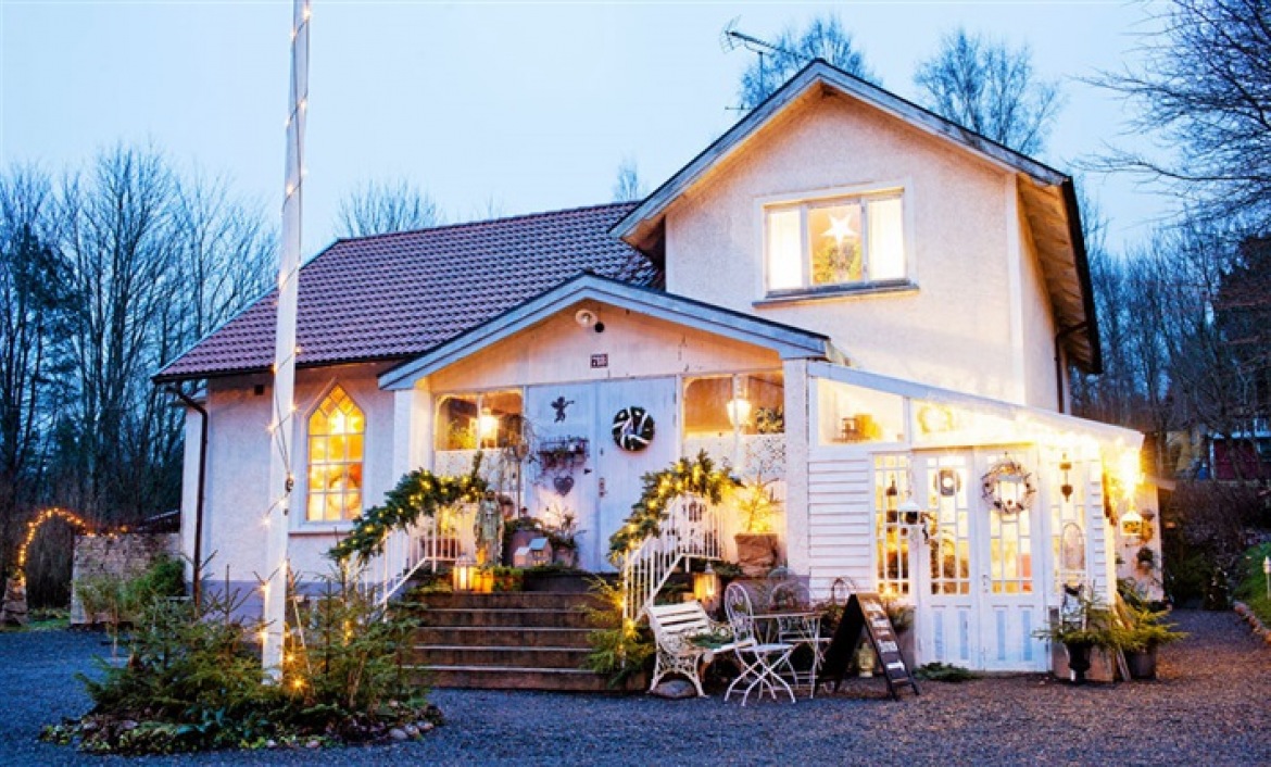 Świąteczne zielone girlandy,zielone wianki z lampkami i choinki w świątecznej aranżacji białego domku w stylu skandynawskim (27502)