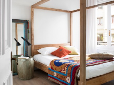 Kolorowa narzuta w etniczne wzory na łóżku z drewnianą konstrukcją wysokich ram (21812)