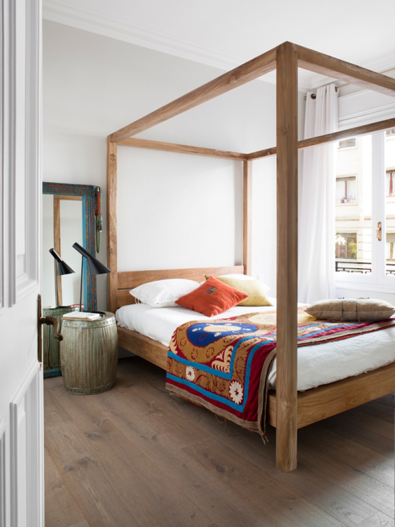 Kolorowa narzuta w etniczne wzory na łóżku z drewnianą konstrukcją wysokich ram (21812)