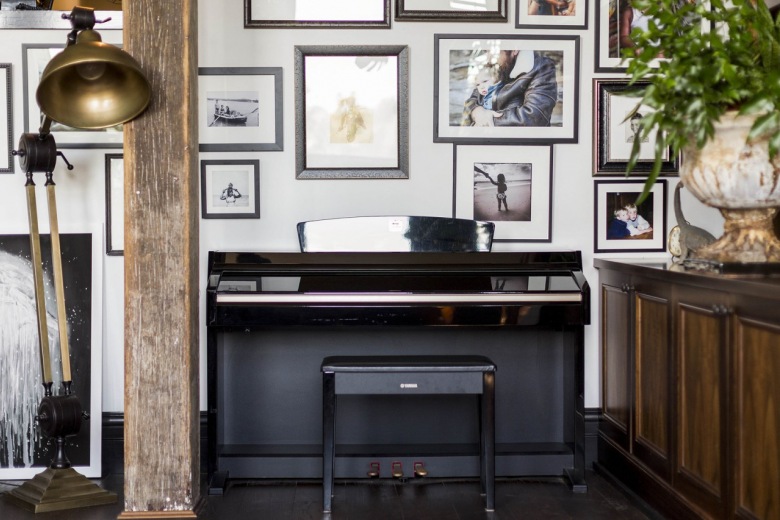 Czarne pianino przy ścianie z galerią w aranżacji salonu (51750)