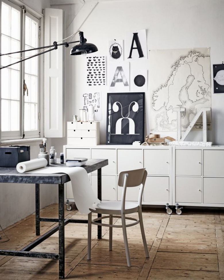 Białe komody na kółkach,czarno-białe grafiki w stylu skandynawskim,metalowe biurko i czarna lampa z wysięgnikiem w domowym biurze (24841)