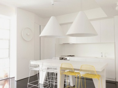 Dizajnerska minimalistyczna kuchnia w bieli z czarną zywiczna podłogą i biało-żółtymi ażurowymi krzesłami (25250)