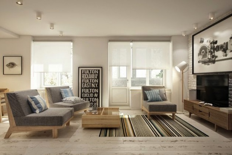 Deski podłogowe z naturalnbego drewna,biała cegła na ścianie,drewniane fotele z szarą tapicerką w tkaninie i tkany dywan w paski w salonie (26856)