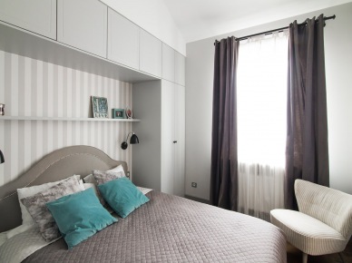 Sypialnię urządzono w różnych odcieniach szarości, uzyskując spokojny, wyciszający klimat. Niektóre dodatki w kolorze, jak zasłony czy poduszki na łóżku w bardzo subtelny sposób dekorują...