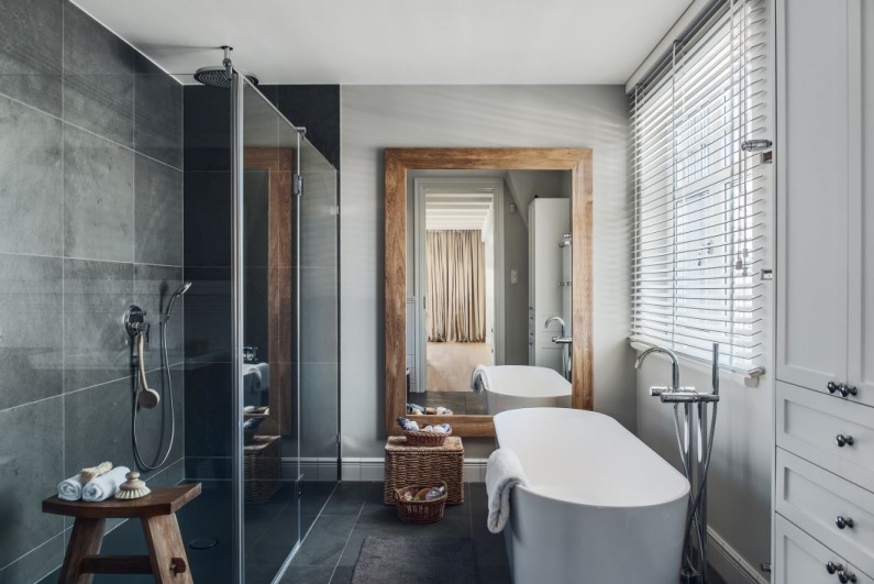 Elegancką łazienkę urozmaicają drewniane i wiklinowe dodatki, wśród których najbardziej wyróżnia się duże lustro w...