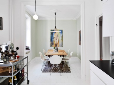 Obraz na białej ścianie w jadalni z drewnianym stołem i białymi nowoczesnymi krzesłami na metalowych krzyżakach (25732)