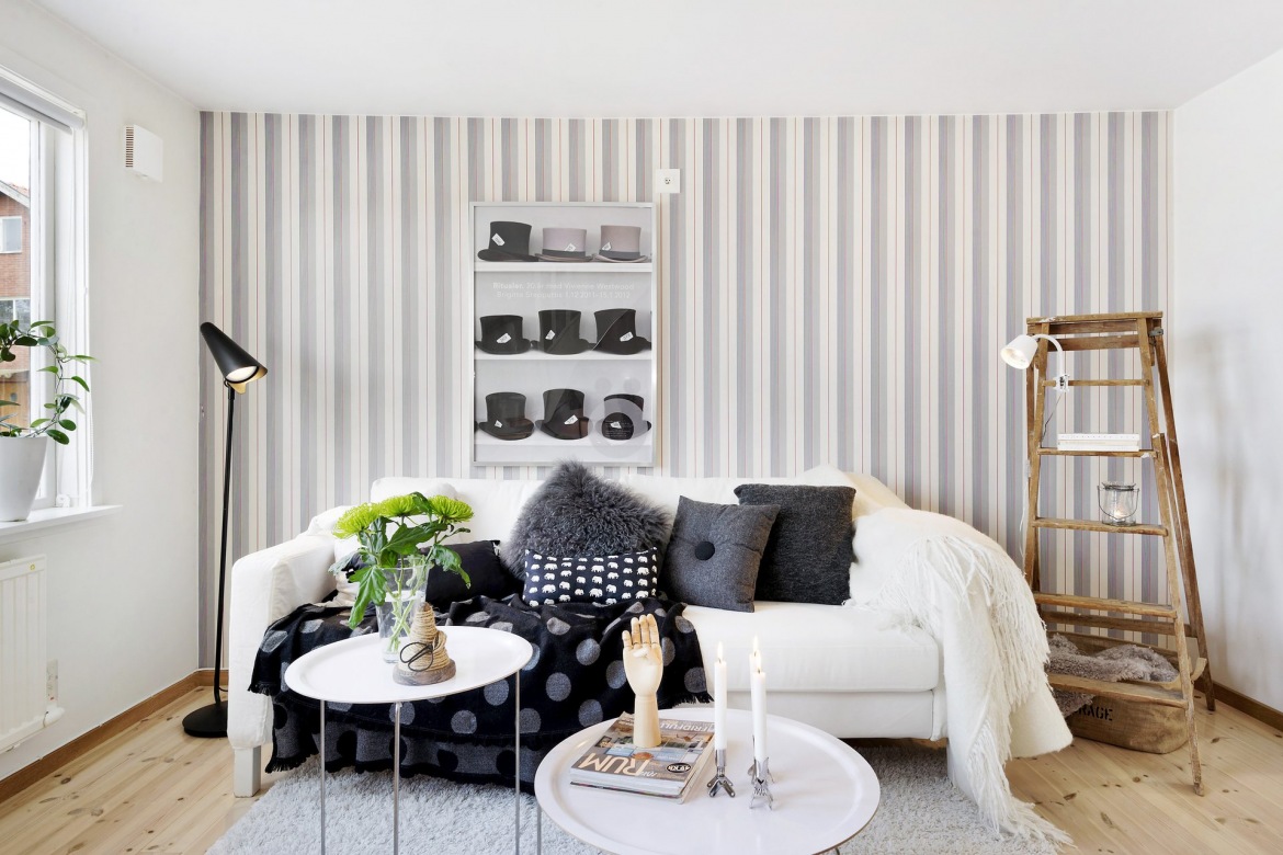 Czarna lampa podłogowa,tapeta w szare paski,biała sofa i okrągłe stoliki kawowe z tacą (23262)