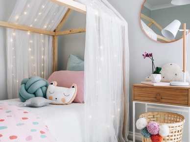 Łóżko domek z tiulem i girlandą świetlną w pokoju dziecięcym (51955)
